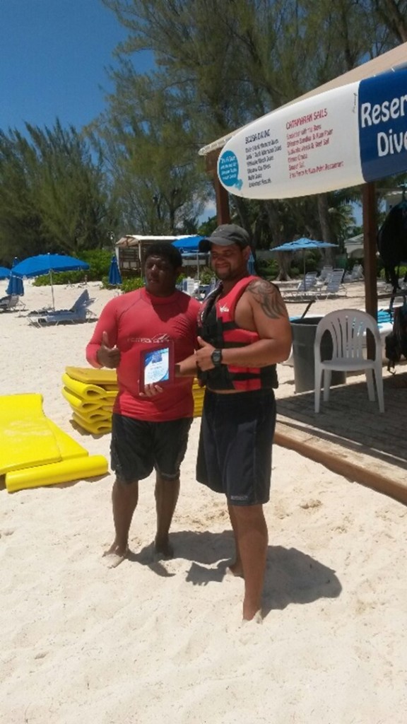 On the beach with the good news and the award are Rueben Gordon (L) and Harvey Smith. Photo courtesy Red Sail Sports.