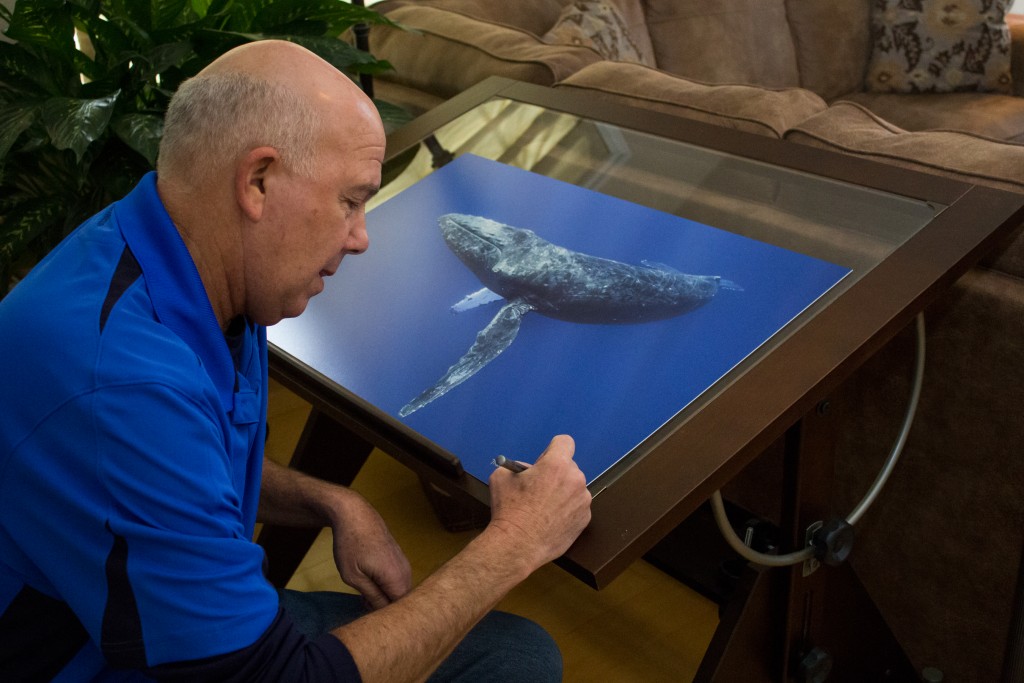 Marty Snyderman signing a print of his photo "Humpback Whales" which will be one of the prizes in the photo contest. Photo courtesy Marty Snyderman and Vivid-Pix